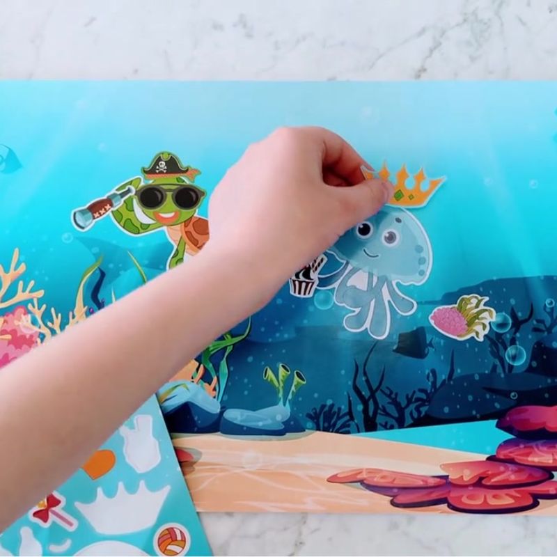 Child placing stickers on an ocean themed sticker poster.