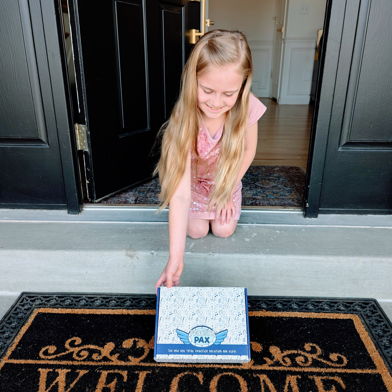 Girl receiving a Practice Pax subscription box from her doorstep.