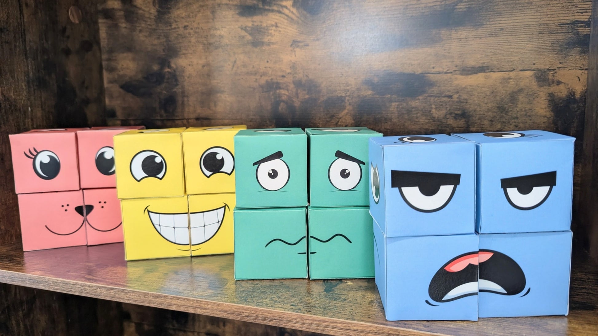 Colorful blocks with facial expressions on a wooden surface