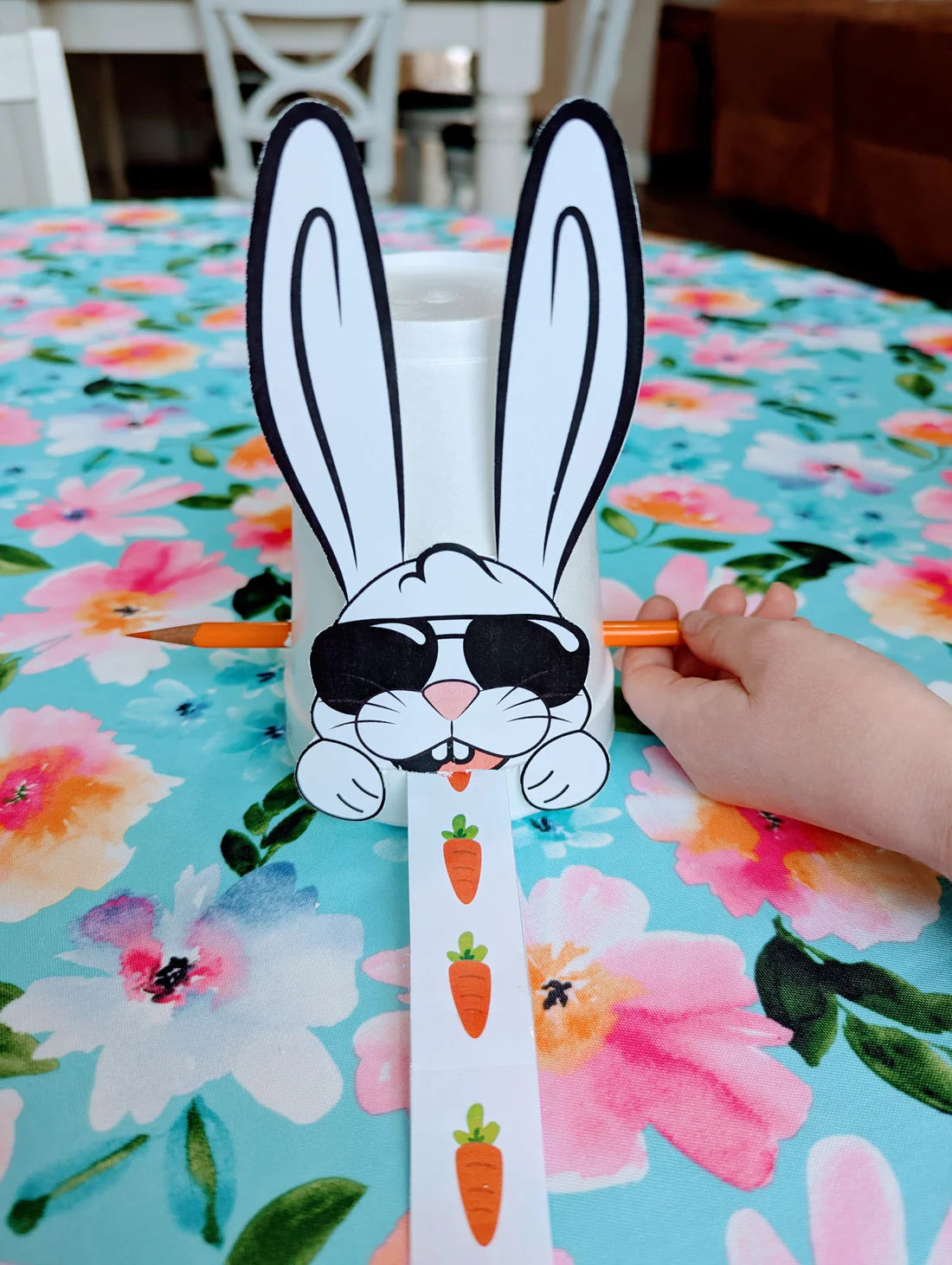 A paper bunny on a cup with carrots for a practice activity